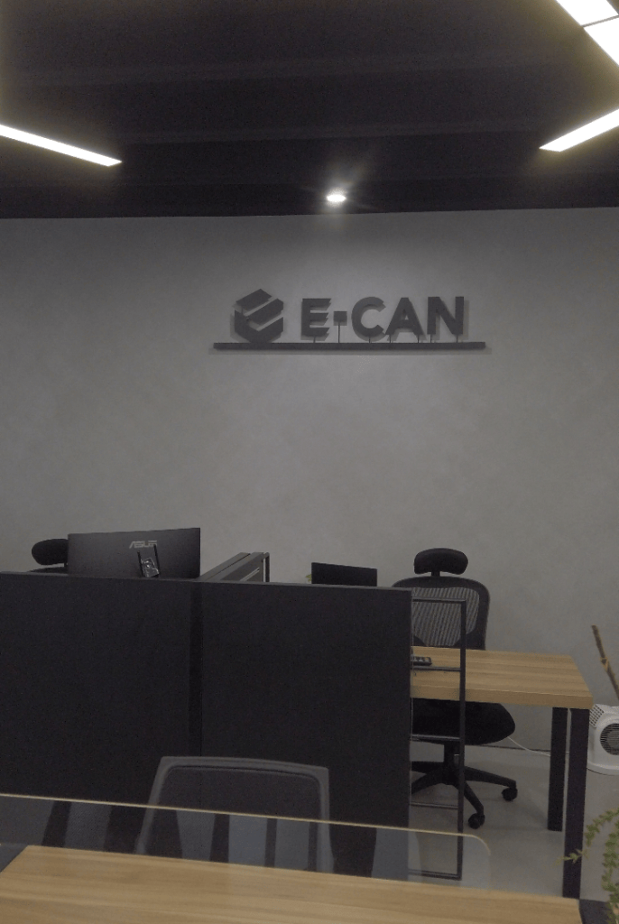 E-CAN brand wall above desks inside the office