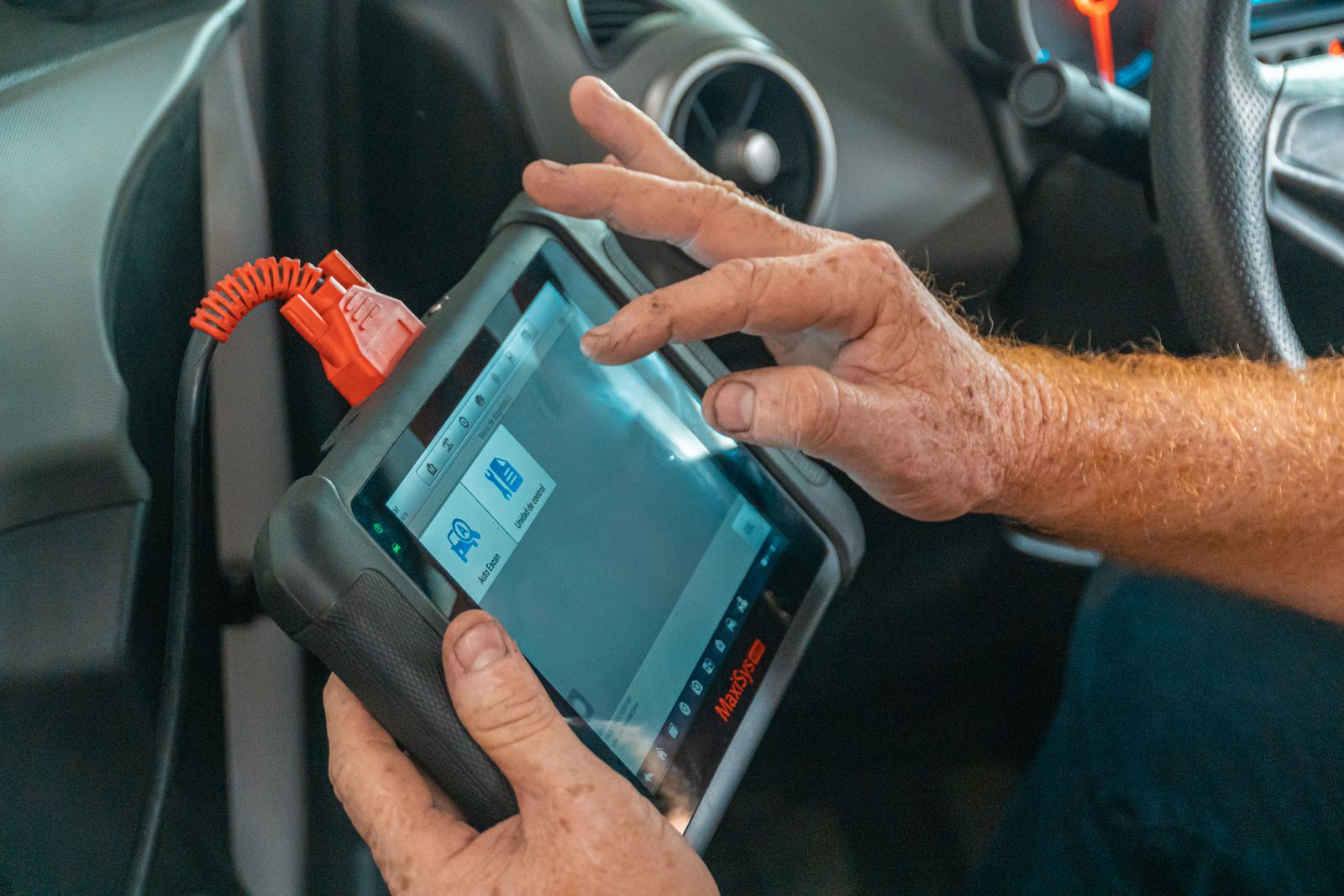 Technician checking a vehicle with a diagnostic tablet